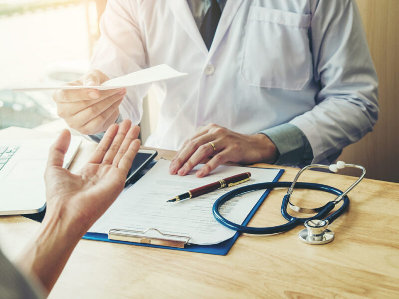 doctor handing patient a prescription