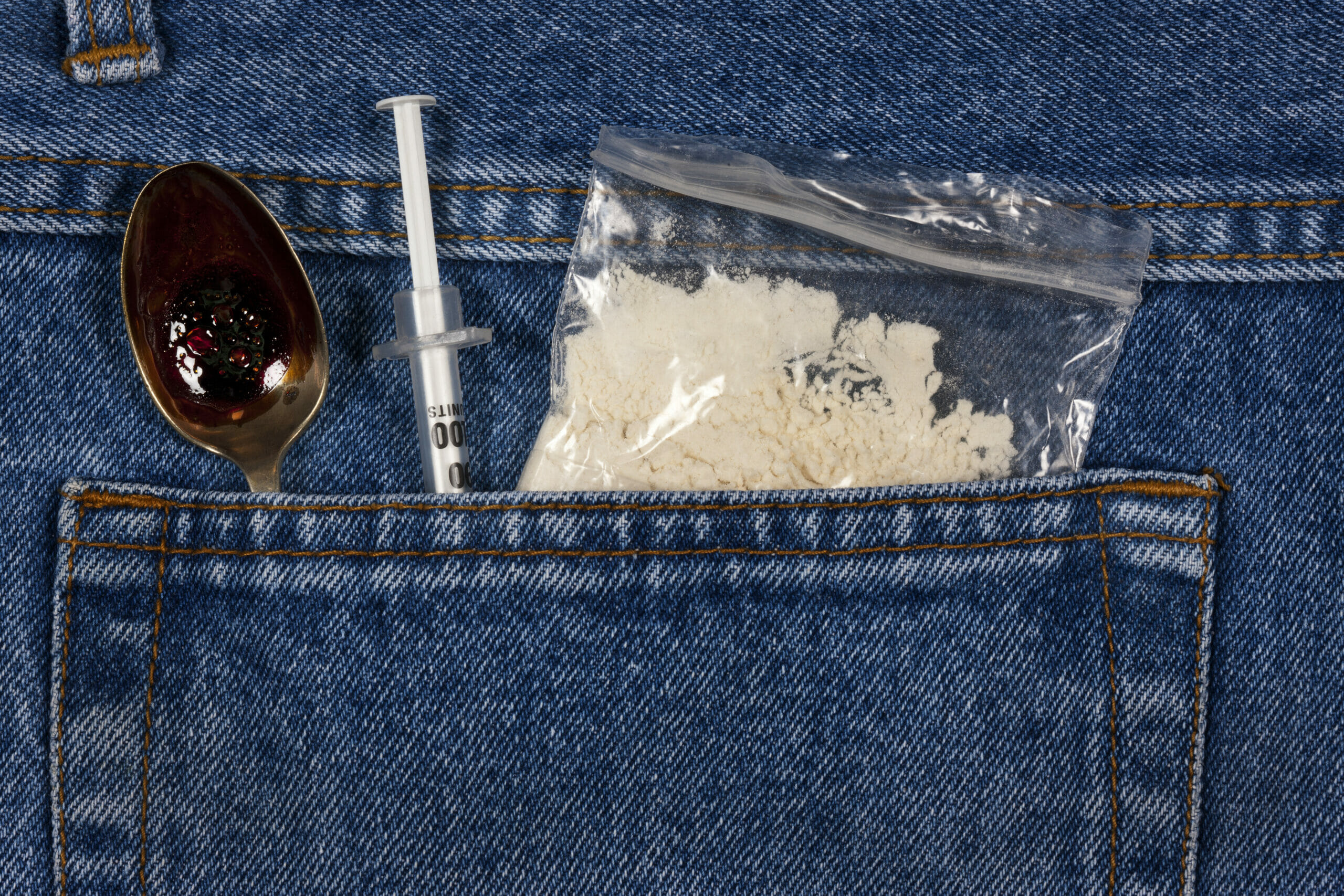 cocaine, spoon, and needle in jeans pocket