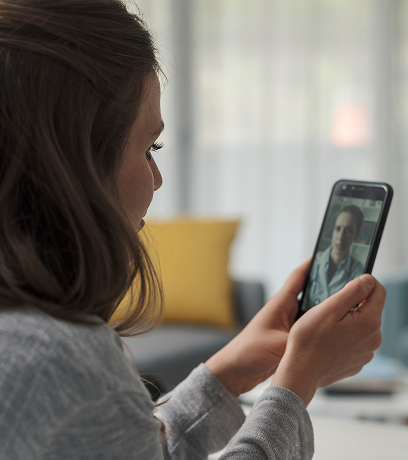 A young adult woman speaking to her therapist via video call.