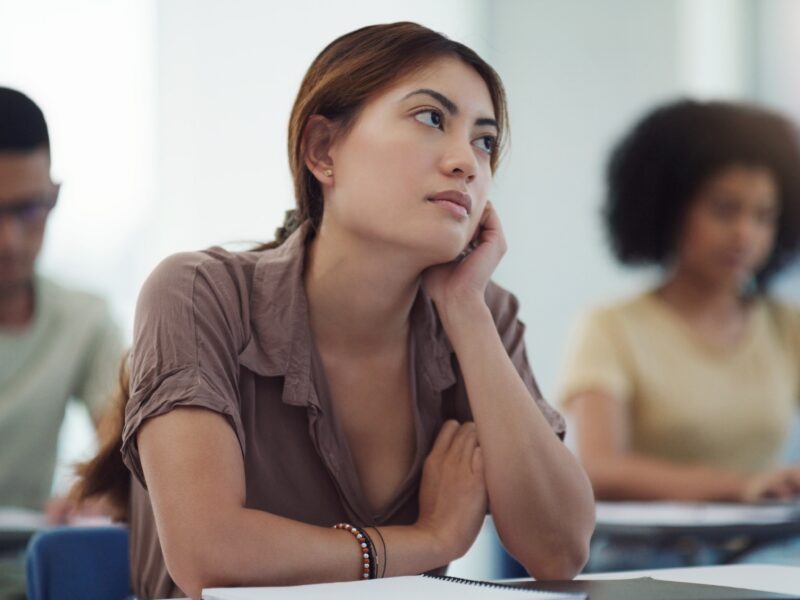 Young woman distracted in class room
