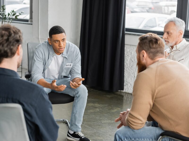 A group of men sitting in a circle going through group therapy